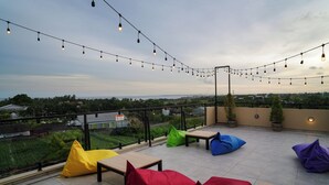 Una terrazza sul tetto con luci decorative, posti a sedere e vista sulla città.