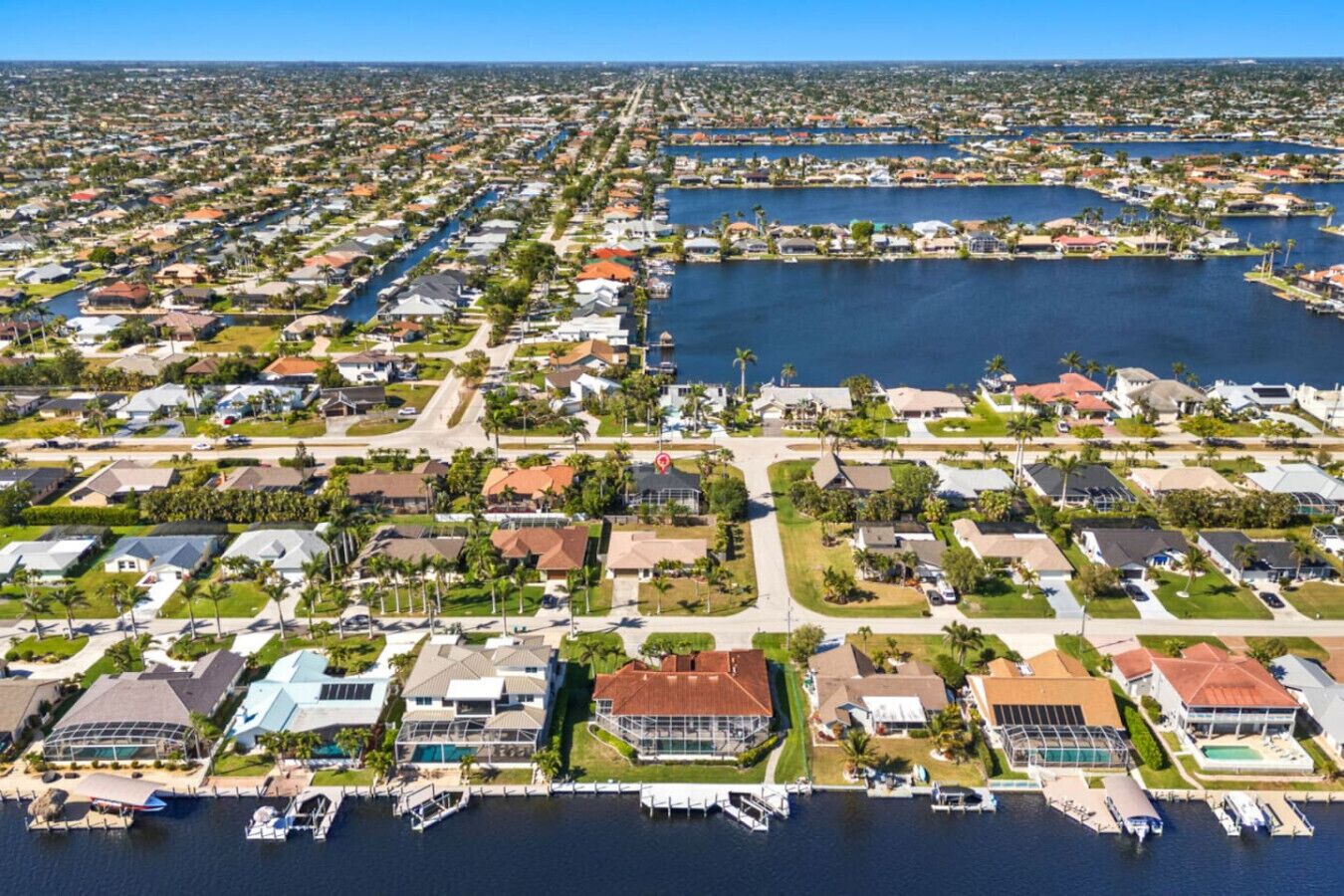 A residential area with houses, a marina, and a large body of water.