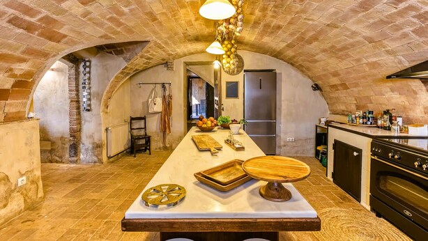 A kitchen with an arched brick ceiling, a central island with a wooden top, and modern appliances. - Charming Charming Village House (AA+Wifi+Swimming Pool) (Riumors)
