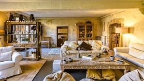 A cozy living room with a fireplace, a coffee table, and a bookshelf. - Charming Charming Village House (AA+Wifi+Swimming Pool) (Riumors)