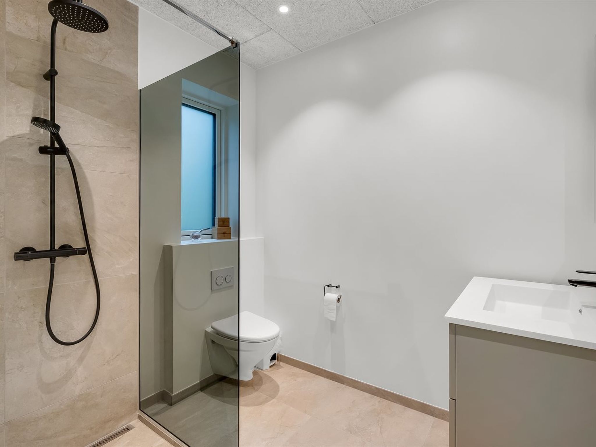 Une salle de bain moderne avec une douche à parois de verre, des toilettes et un lavabo.