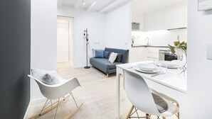 A modern living space with a dining area, a sofa, and a kitchen. - Easylife - Comfort and elegance in Porta Venezia (Milano)