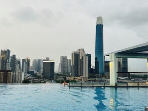 A swimming pool with a city skyline in the background. - D'Majestic Place by Roomy (Kuala Lumpur)