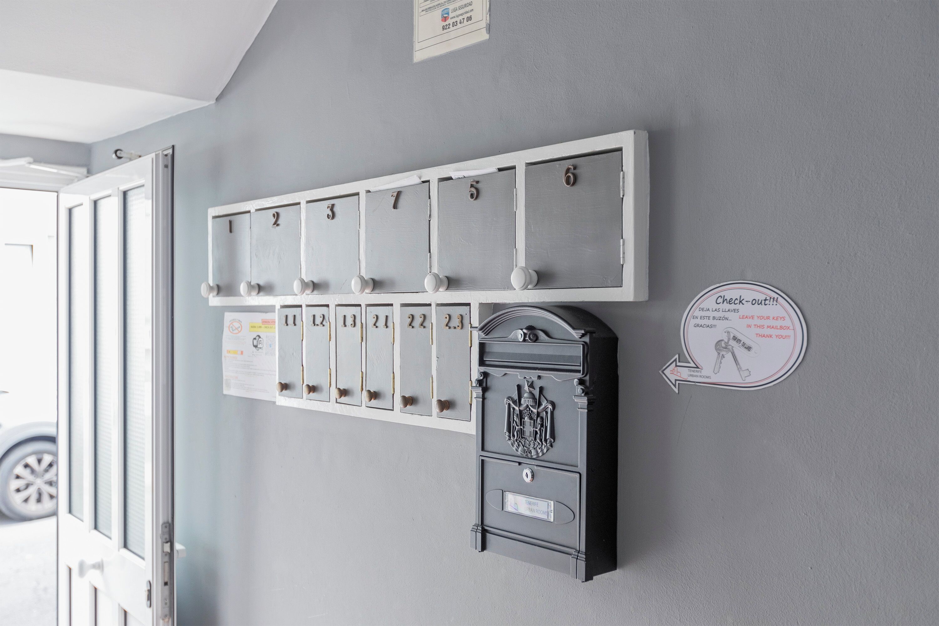 Una cassetta postale a muro con scomparti numerati e una piccola casella nera.