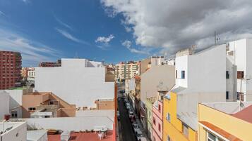 Una calle estrecha bordeada de edificios coloridos, una plaza con tejas rojas y un cielo despejado.