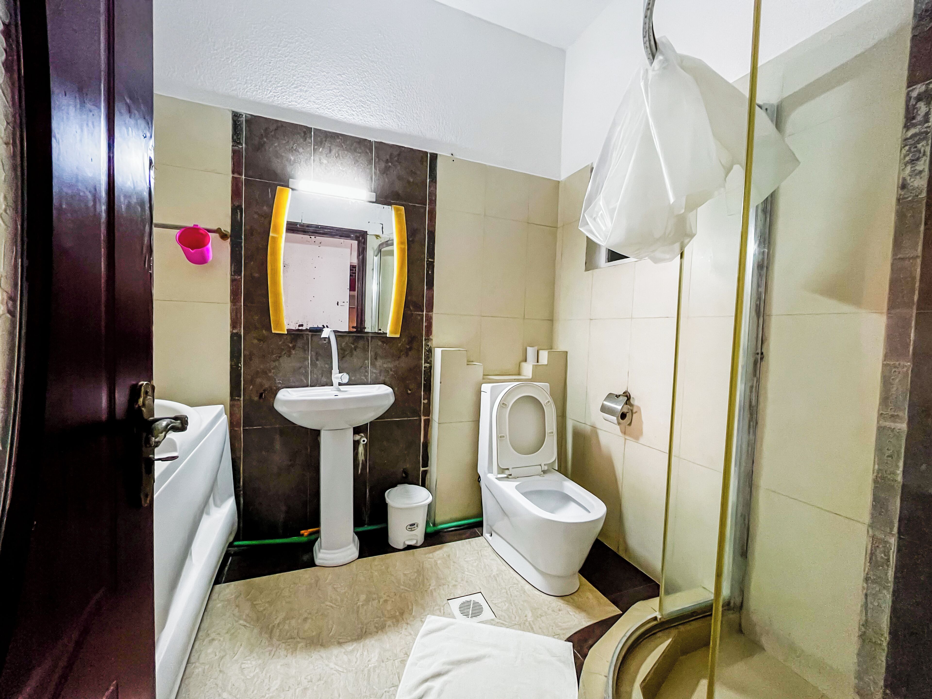 A bathroom with a white sink, a toilet, and a shower area.
