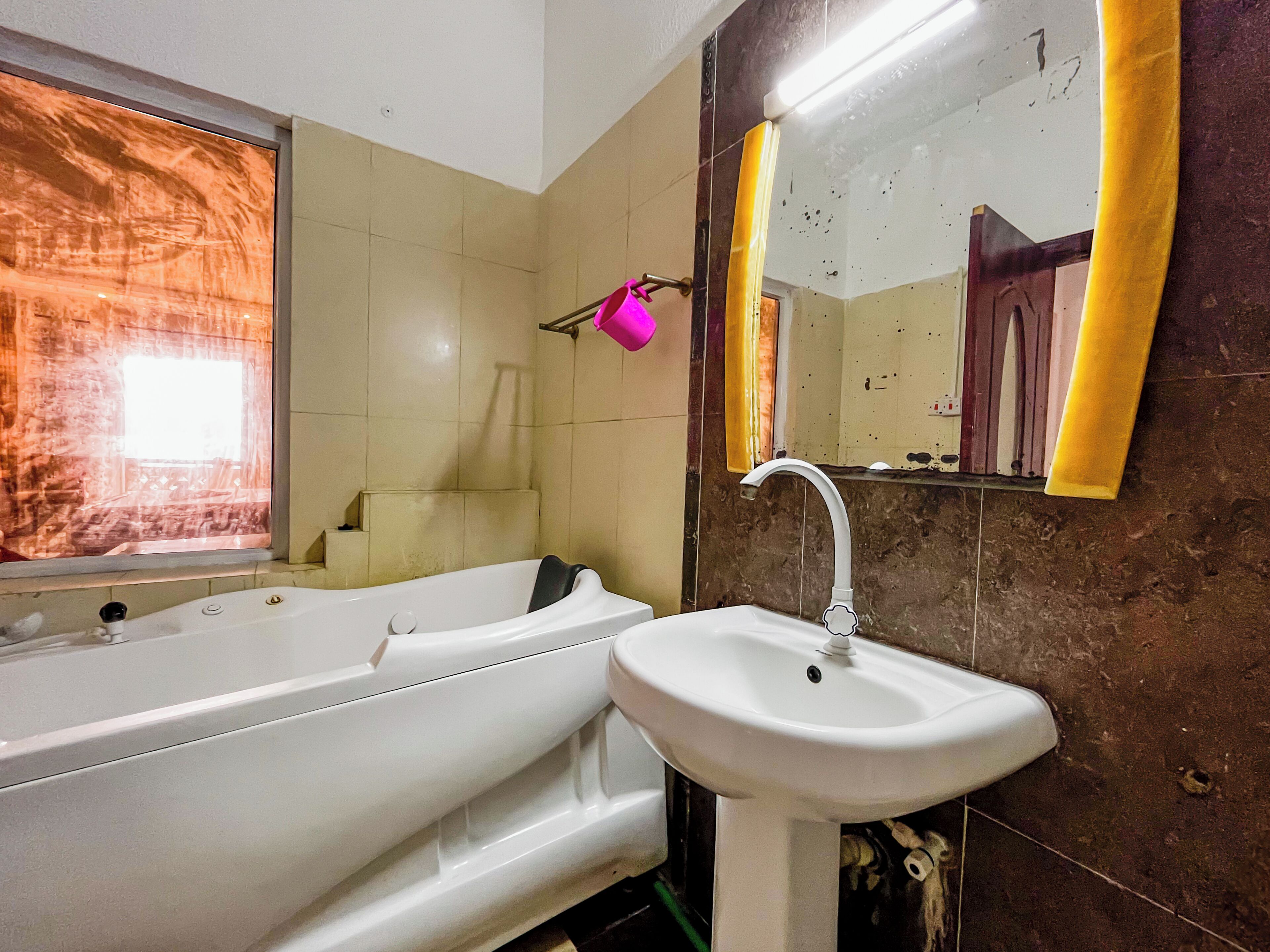 A bathroom with a bathtub, sink, and mirror.