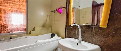 A bathroom with a bathtub, sink, and mirror.
