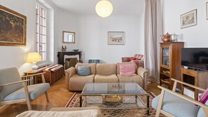 Una sala de estar con sofá, sillones, una mesa de centro, chimenea y televisión.