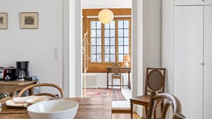Un comedor acogedor con una mesa de madera, sillas y una lámpara colgante.