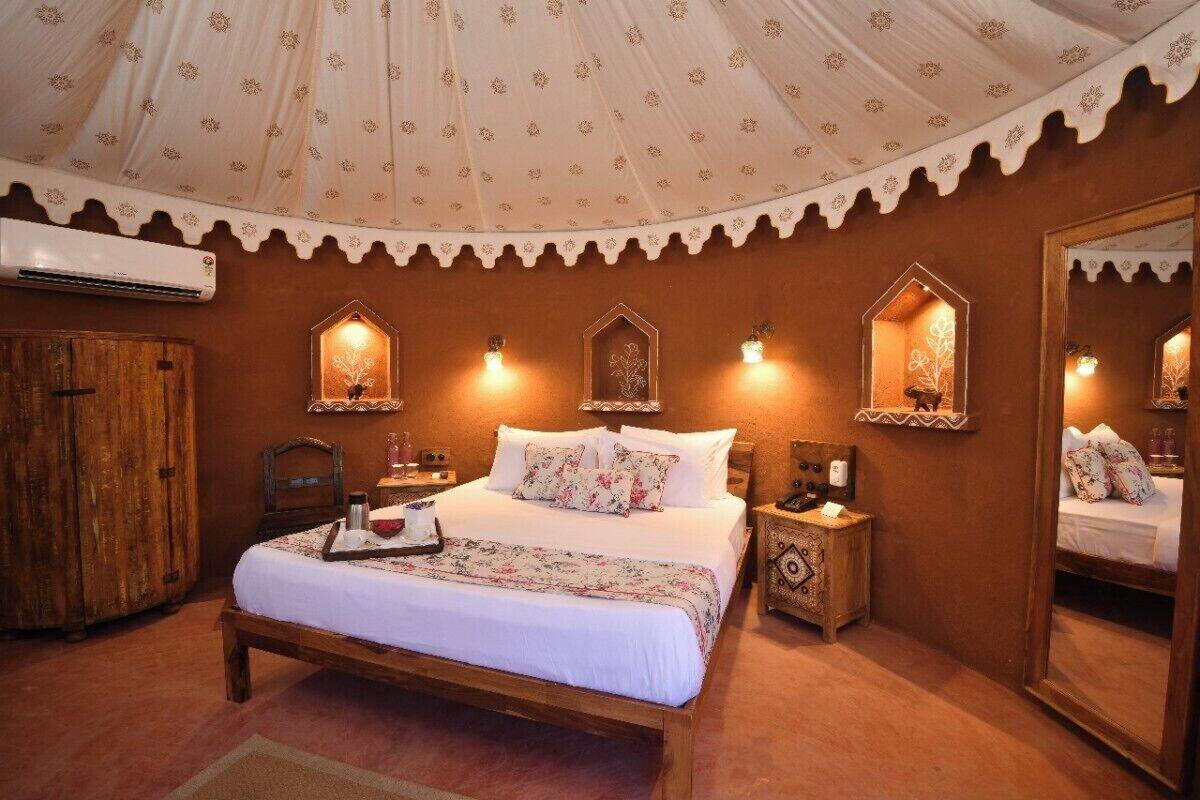 A traditional room with a bed, wooden furniture, and decorative wall sconces.