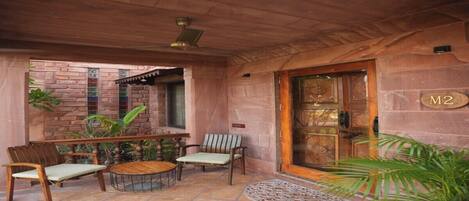 A covered patio area with a stone wall, a wooden ceiling, and a door marked "M2".