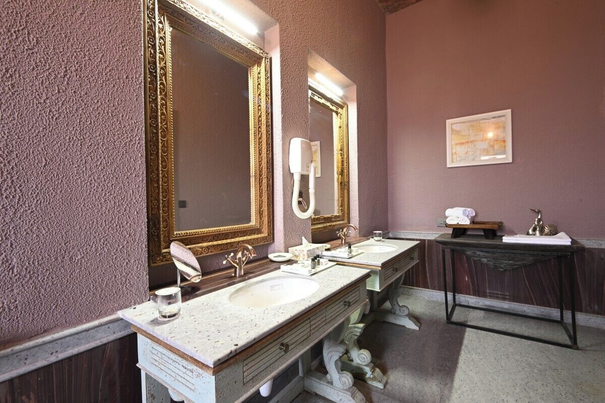A bathroom with two sinks, a large mirror, and a vanity with a dark countertop.