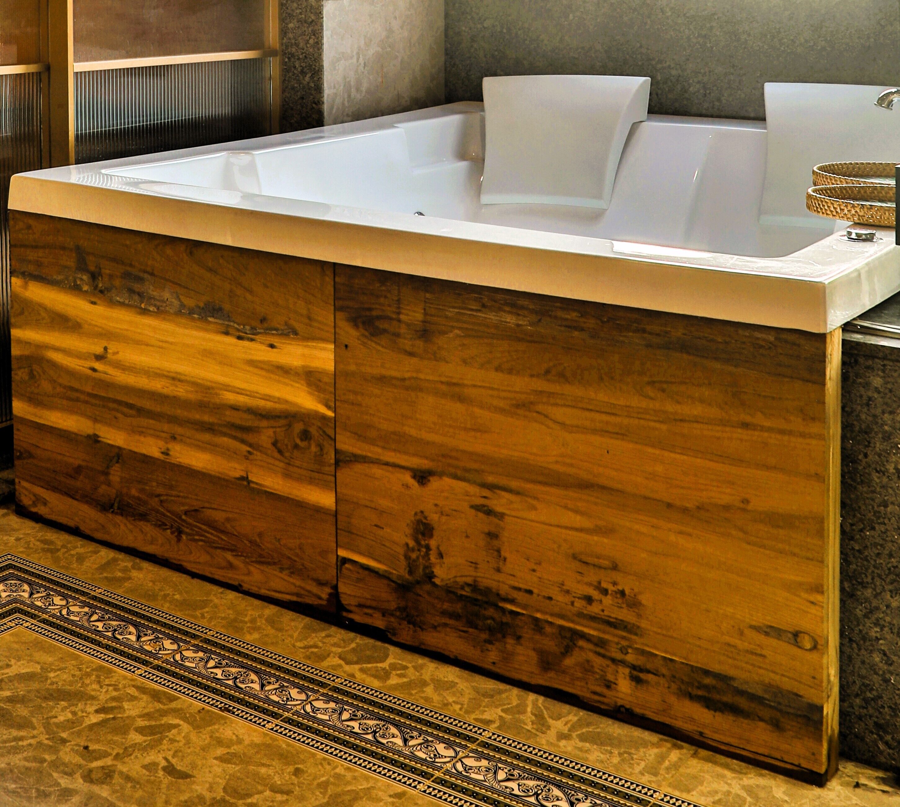 A modern bathroom with a wooden vanity, a bathtub, and a small sink.