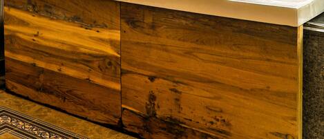 A modern bathroom with a wooden vanity, a bathtub, and a small sink.