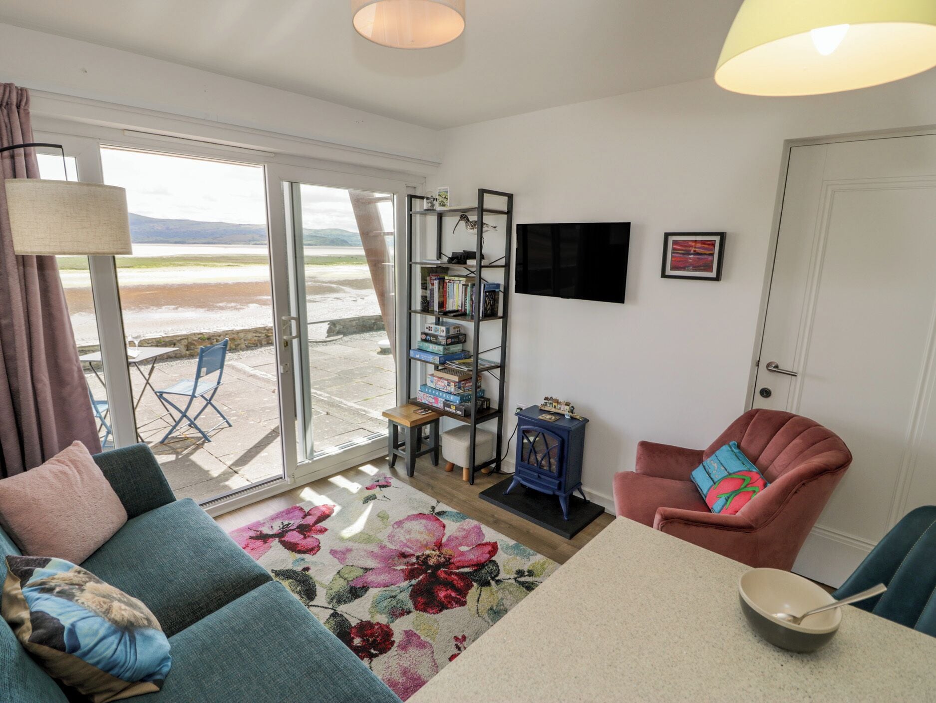 A living room with a sofa, a chair, a coffee table, a bookshelf, and a TV.