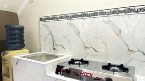 A kitchen with a Hock gas stove, a water dispenser, and a sink. - Griya Inn (Semarang)