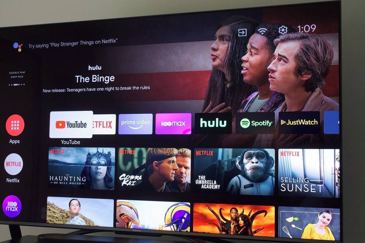 A TV screen displaying a streaming service interface with multiple app icons and movie thumbnails.