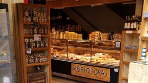 Une devanture de magasin avec une vitrine remplie de divers produits alimentaires et une enseigne indiquant « ALBIE FOIE GRAS ».