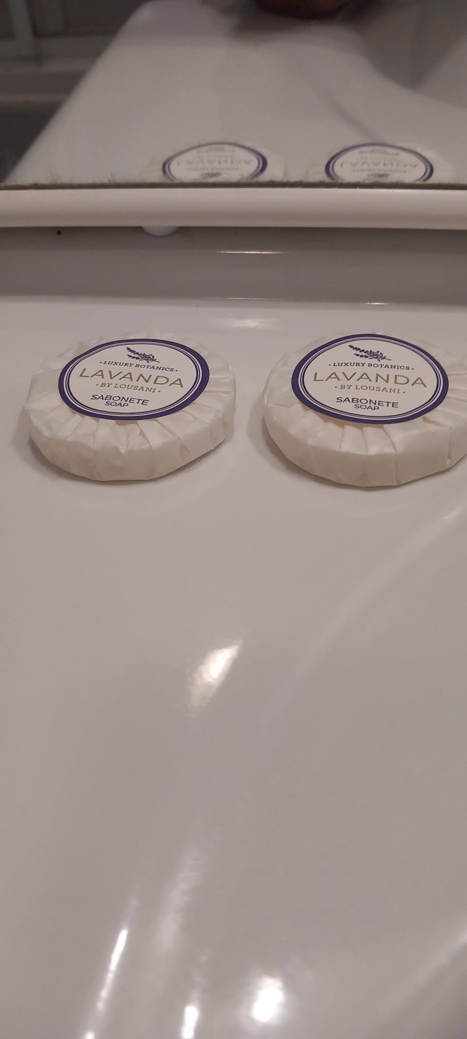 Two round soap bars on a white surface.