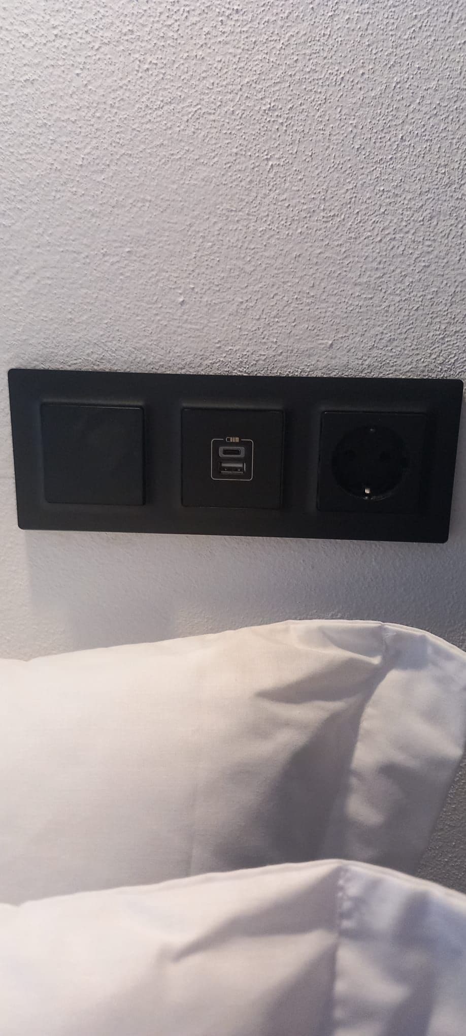 Ein an der Wand montiertes Verteilerkasten mit zwei Schaltern und einem USB-Anschluss.