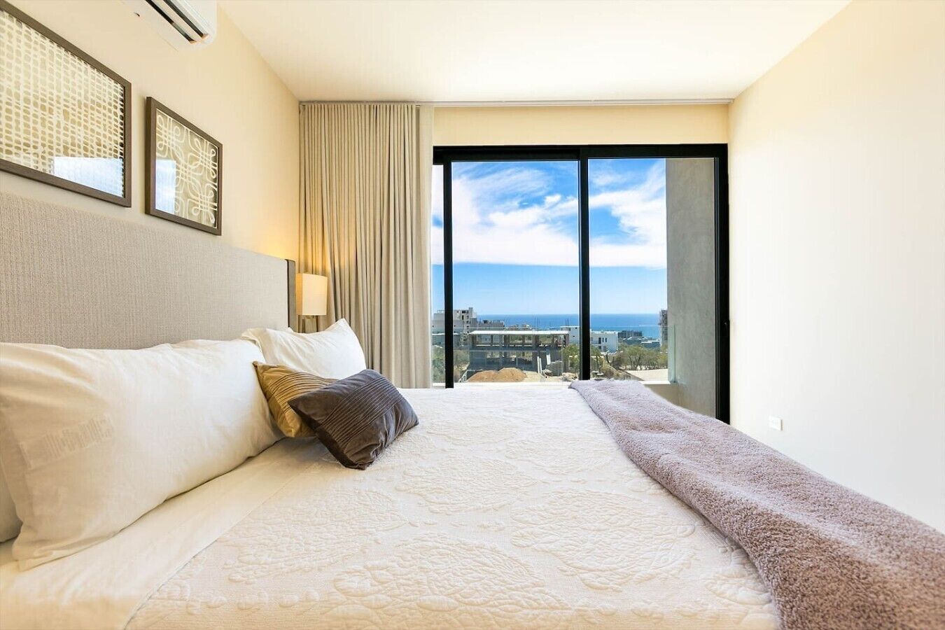 Et hotelværelse med en stor seng, havudsigt og en balkon.