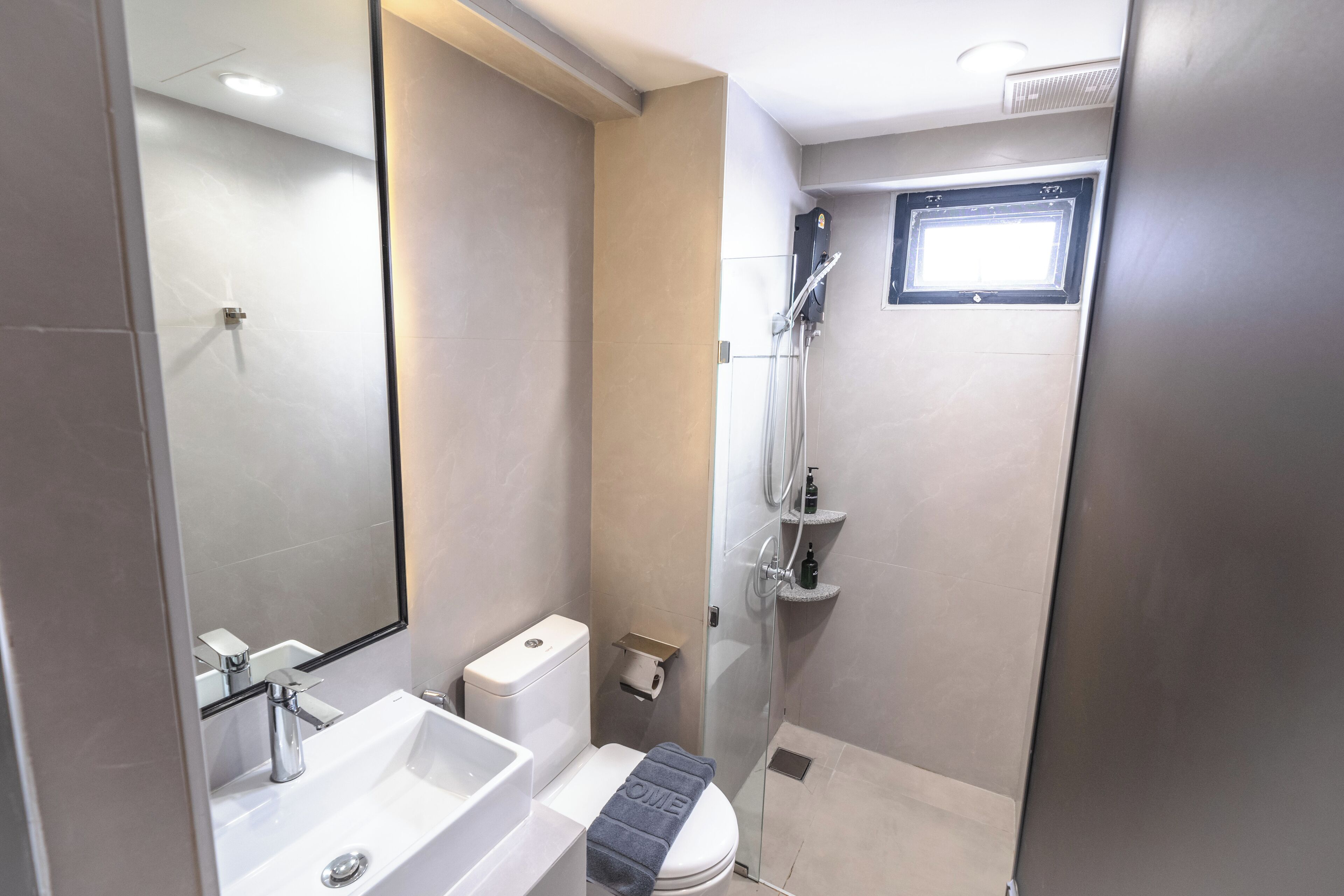 A modern bathroom with a white sink, toilet, and shower.