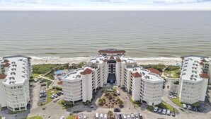 Ein Strandhotel mit mehreren Gebäuden, einem zentralen Innenhof und einem Parkplatz.