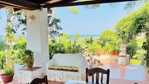A covered outdoor dining area with a long table, chairs, and a bench. - Your Stay at Villa Calipso - The Perfect Family Escape by the Sea (Taranto)