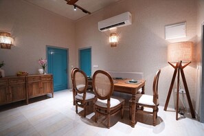Cozy dining area with a wooden table and four chairs, featuring a light-colored floor and a wooden beam ceiling.