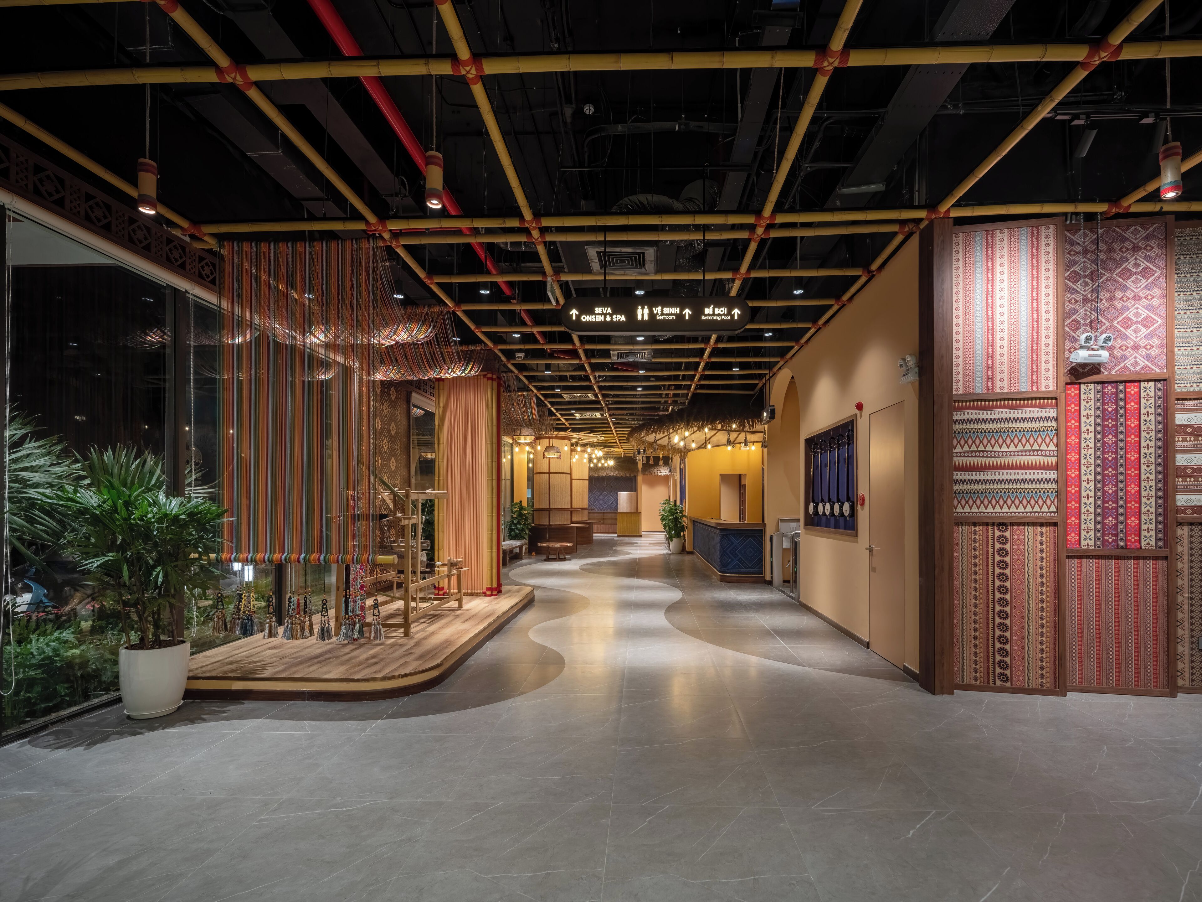 A modern hotel lobby with a curved floor, wooden accents, and a reception desk.