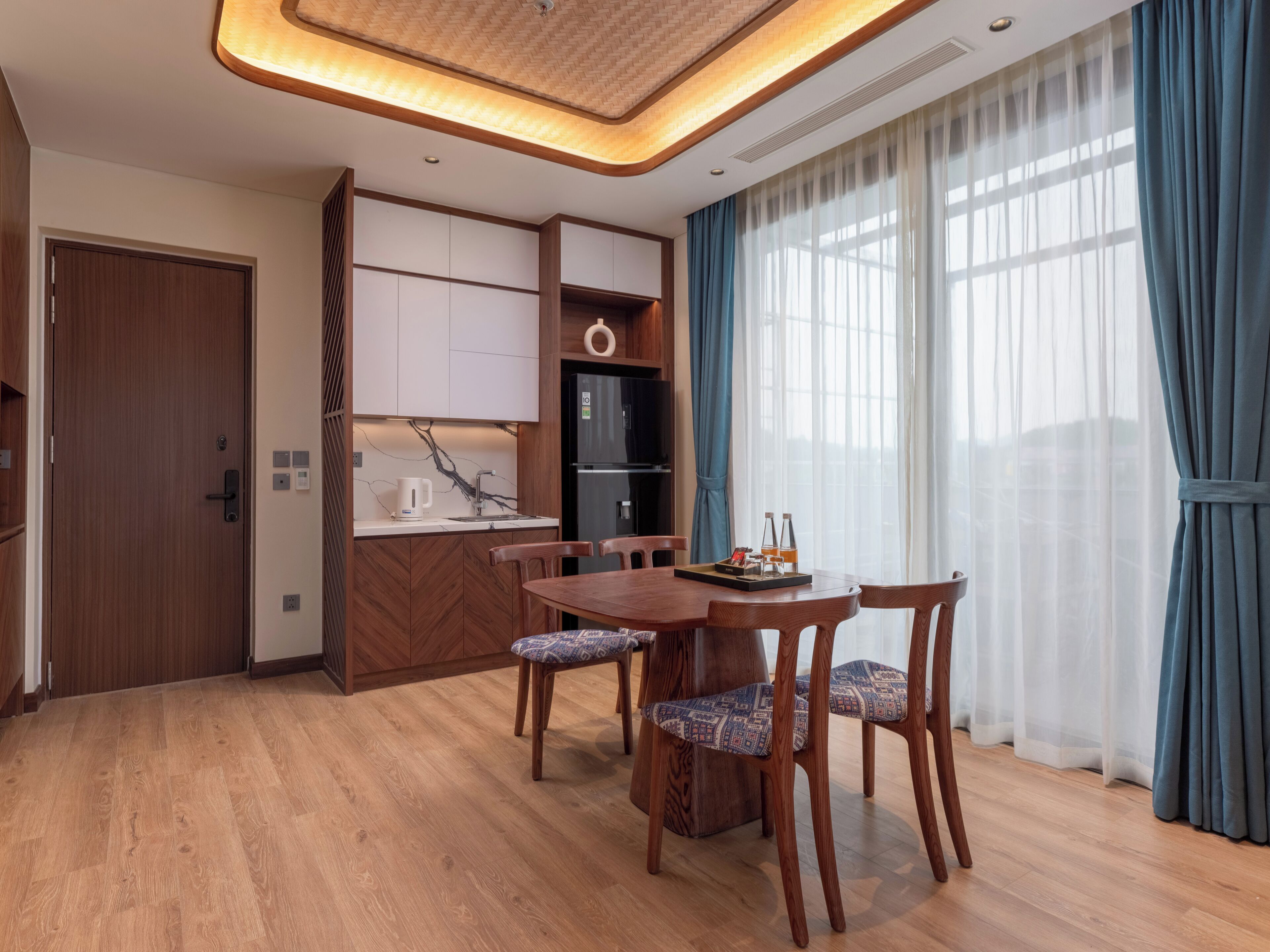 Una cocina moderna con refrigerador empotrado, armarios de madera y cafetera.