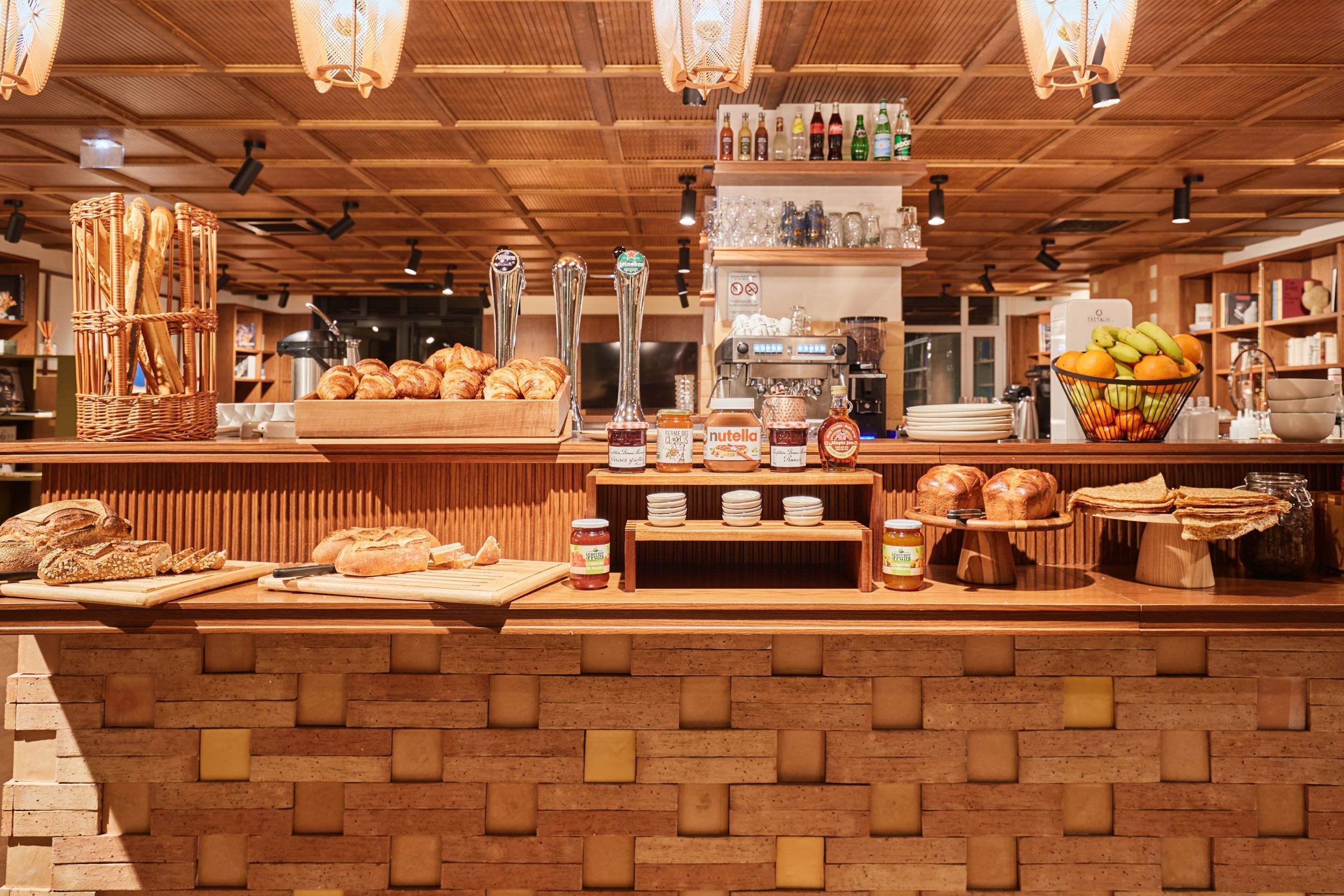 A bakery counter with various breads, pastries, and condiments.