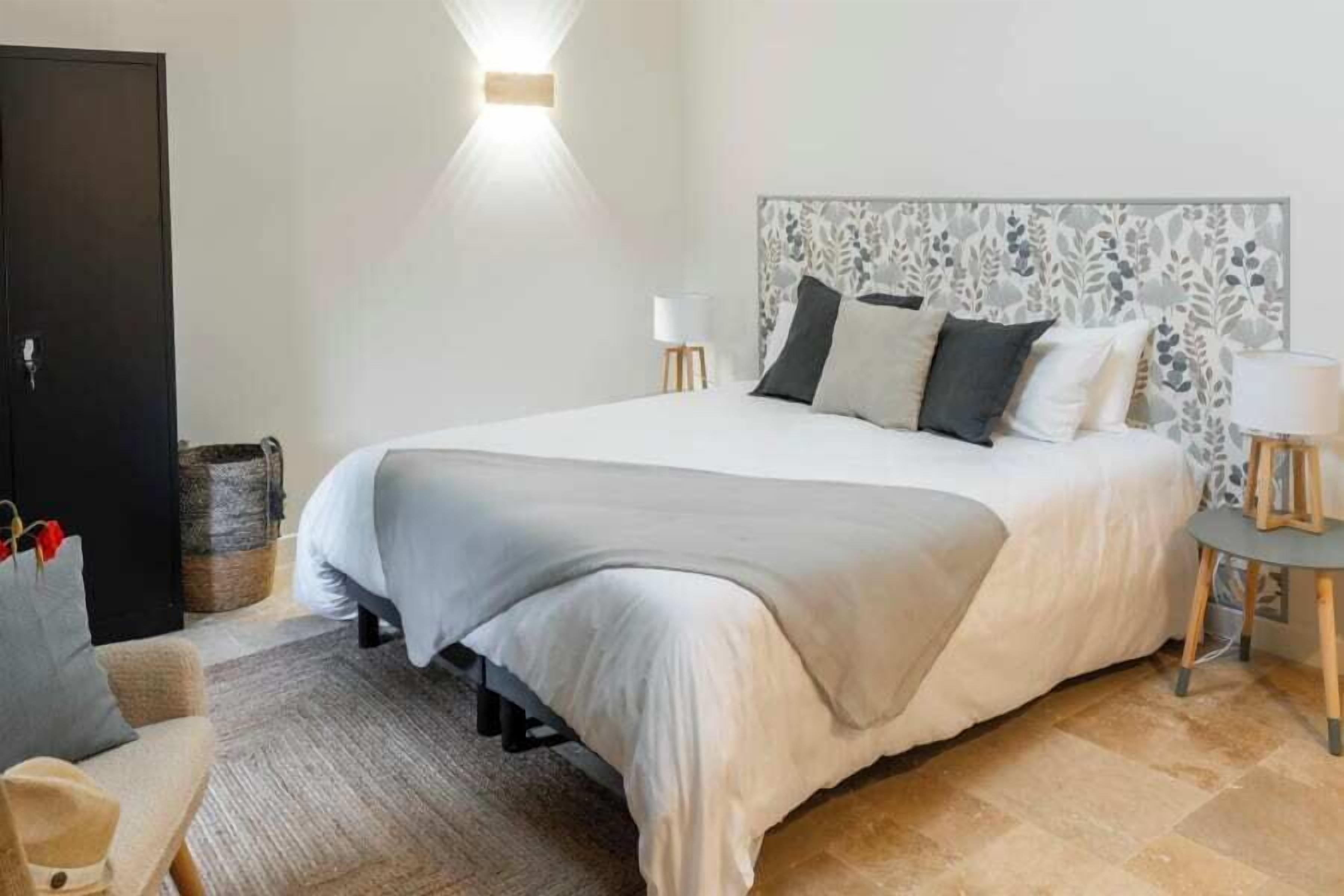 Ein Schlafzimmer mit einem großen Bett, einem Nachttisch, einer Lampe und einem Kleiderschrank.