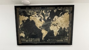 A reception desk with a world map mural above it. - Corso Italia 72 (Catania)