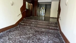 A staircase with a patterned floor leading to an upper level. - Corso Italia 72 (Catania)