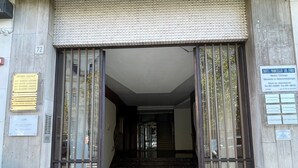 A building entrance with a tiled roof, a set of double doors, and a marble floor. - Corso Italia 72 (Catania)