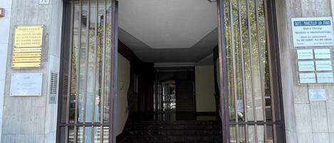 A building entrance with a tiled roof, a set of double doors, and a marble floor.