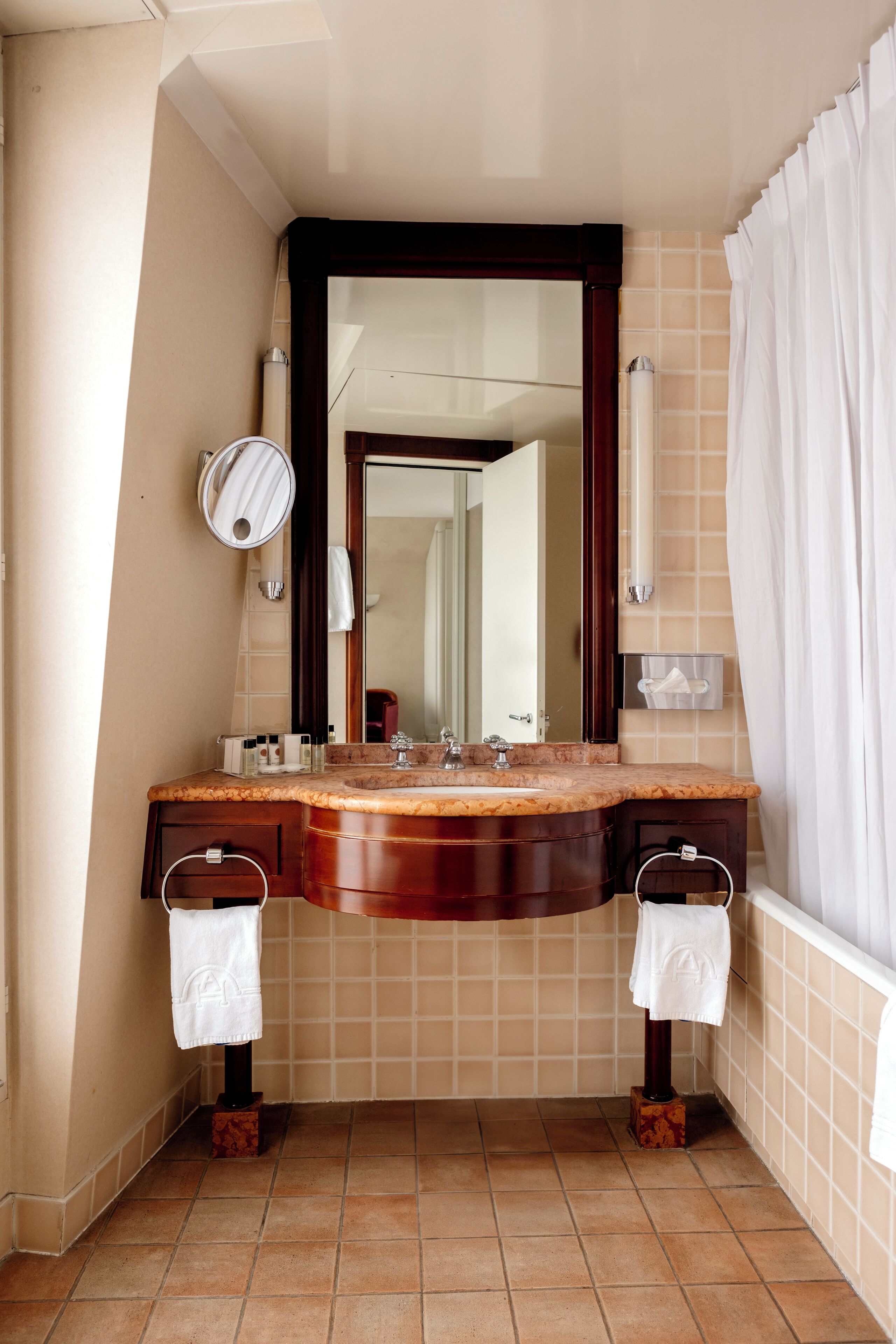 A bathroom with a marble sink, a large mirror, and a shower curtain.