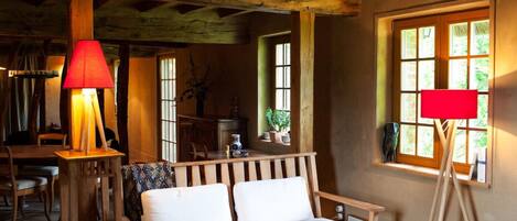 Un interior rústico con un sofá de madera, una mesa y una lámpara.