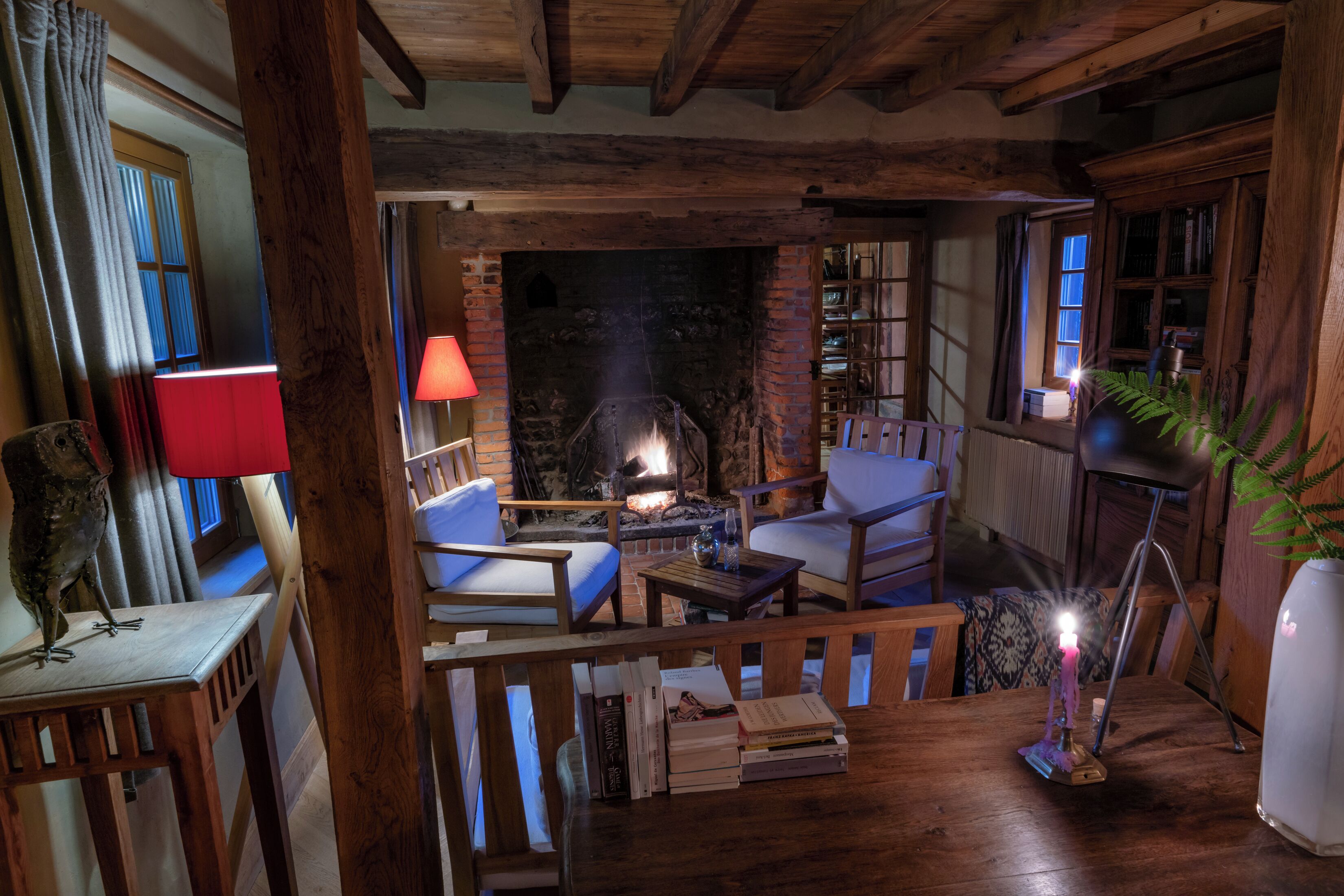 A cozy room with a fireplace, wooden furniture, and books.