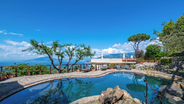 Un ciel d’un bleu limpide, une piscine et une vue sur la mer.