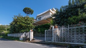Une propriété résidentielle dotée d’une entrée sécurisée, d’un balcon et d’une végétation luxuriante.