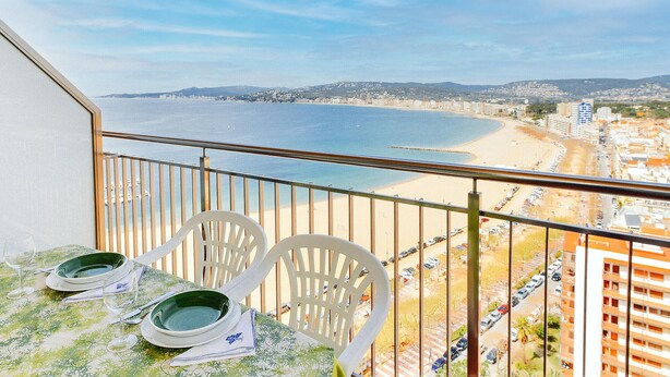 A balcony with a view of a beach and cityscape.