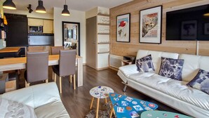 Ein modernes Wohnzimmer mit einer Couch, einem Couchtisch und einem Essbereich mit Stühlen und Tisch.