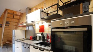 Une cuisine moderne dotée d’appareils électroménagers en acier inoxydable, de meubles blancs et d’éléments décoratifs en bois.