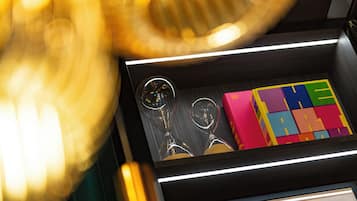 Primer plano de un cajón con un cuadro enmarco, un par de gafas y bloques de colores.