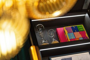 Un primo piano di un cassetto con una cornice, un paio di occhiali e dei blocchi colorati.