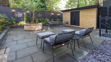 A patio with stone flooring, outdoor furniture, and a brick wall.
