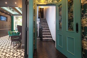 A staircase with a patterned carpet leading to a door marked 101.